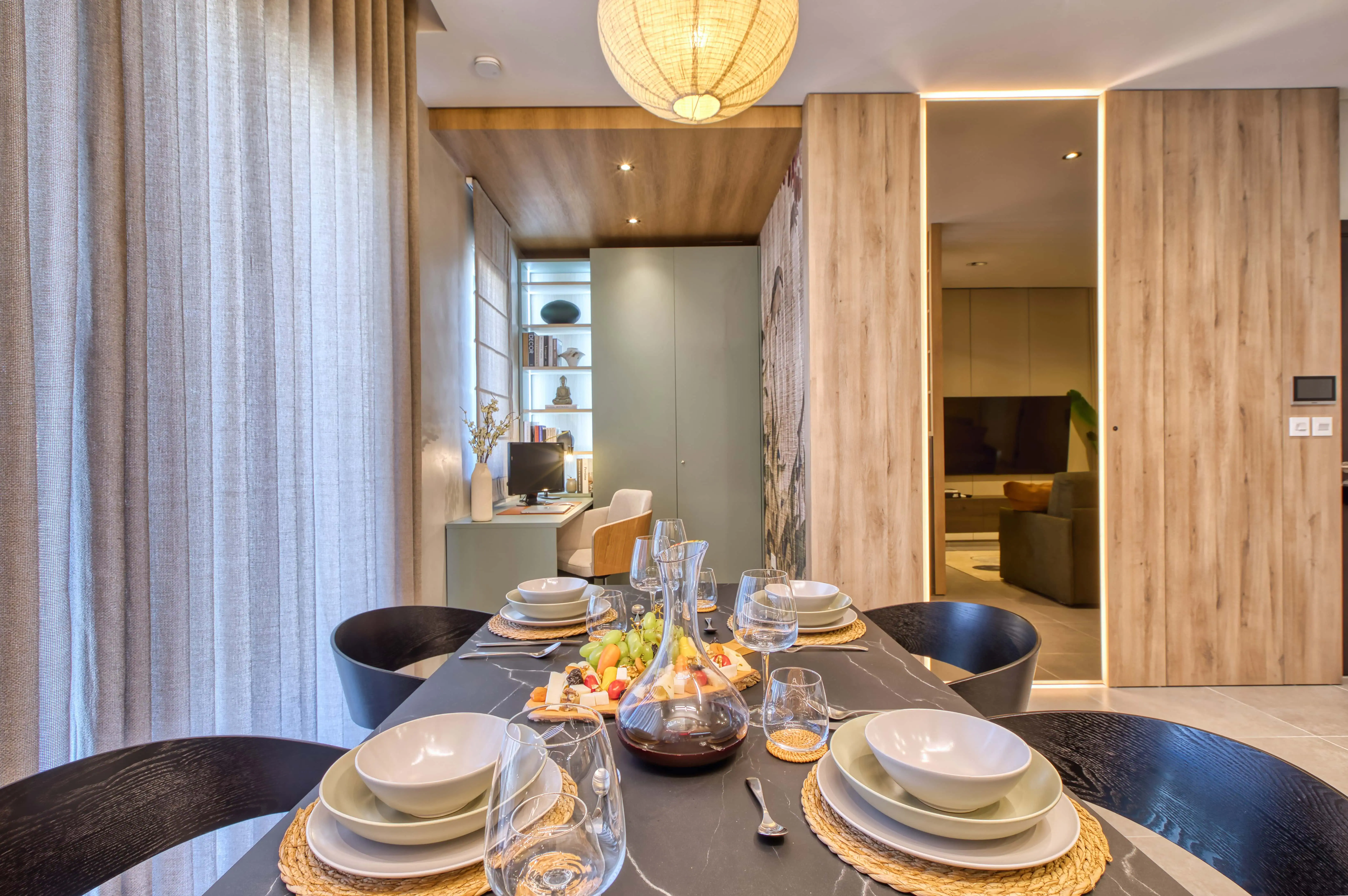 The marble dining table overlooks the study area and seamlessly flows into the open-plan living space, creating a light, airy, and connected penthouse layout.