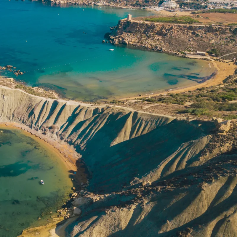 A drone shot of the clay cliffs between Gnejna bay and Ghajn Tuffieha bay. Golden bay is also visible in the distance.