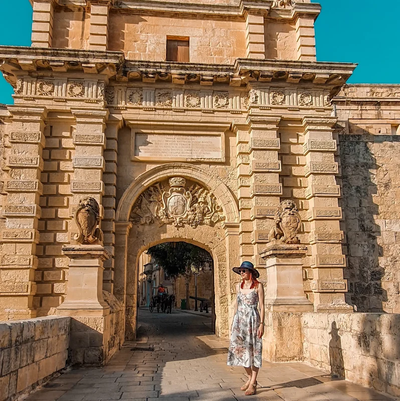 An image of a woman standing in front of Mdina gate, the main entrance to Malta's past capital and witness to the Great Siege of 1565