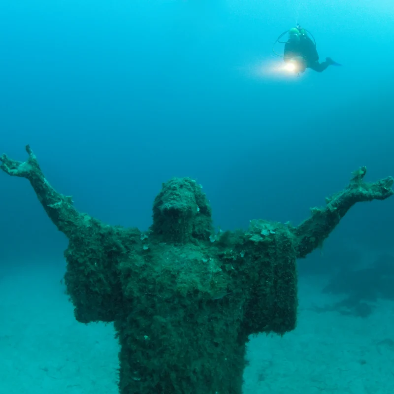 An image of the statue of Christ wreck in St Paul's bay, including a diver. A popular diving spot and experience during a Malta holiday.